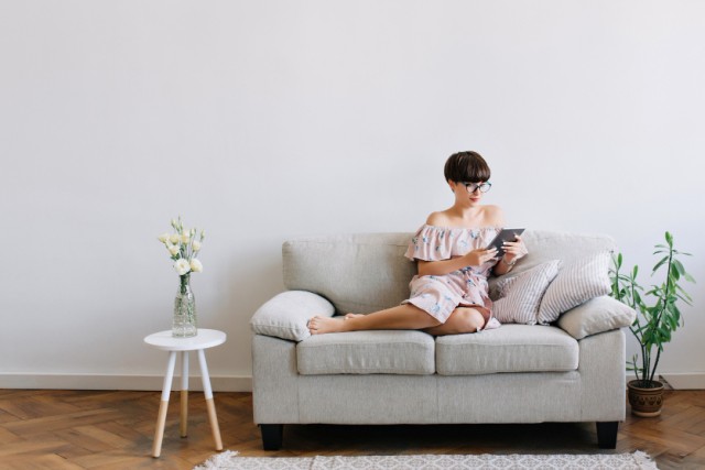 Mujer de 40 años disfrutando de un rato de relax en su sofá pequeño
