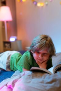Adolescente leyendo un libro en su cama juvenil