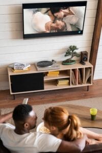 Matrimonio valenciano disfrutando de un rato juntos viendo la TV en casa