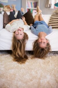 Hermanos preadolescentes jugando en el sofá de su casa